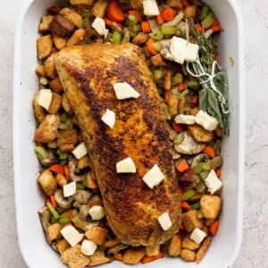 A white baking dish filled with chicken and vegetables.