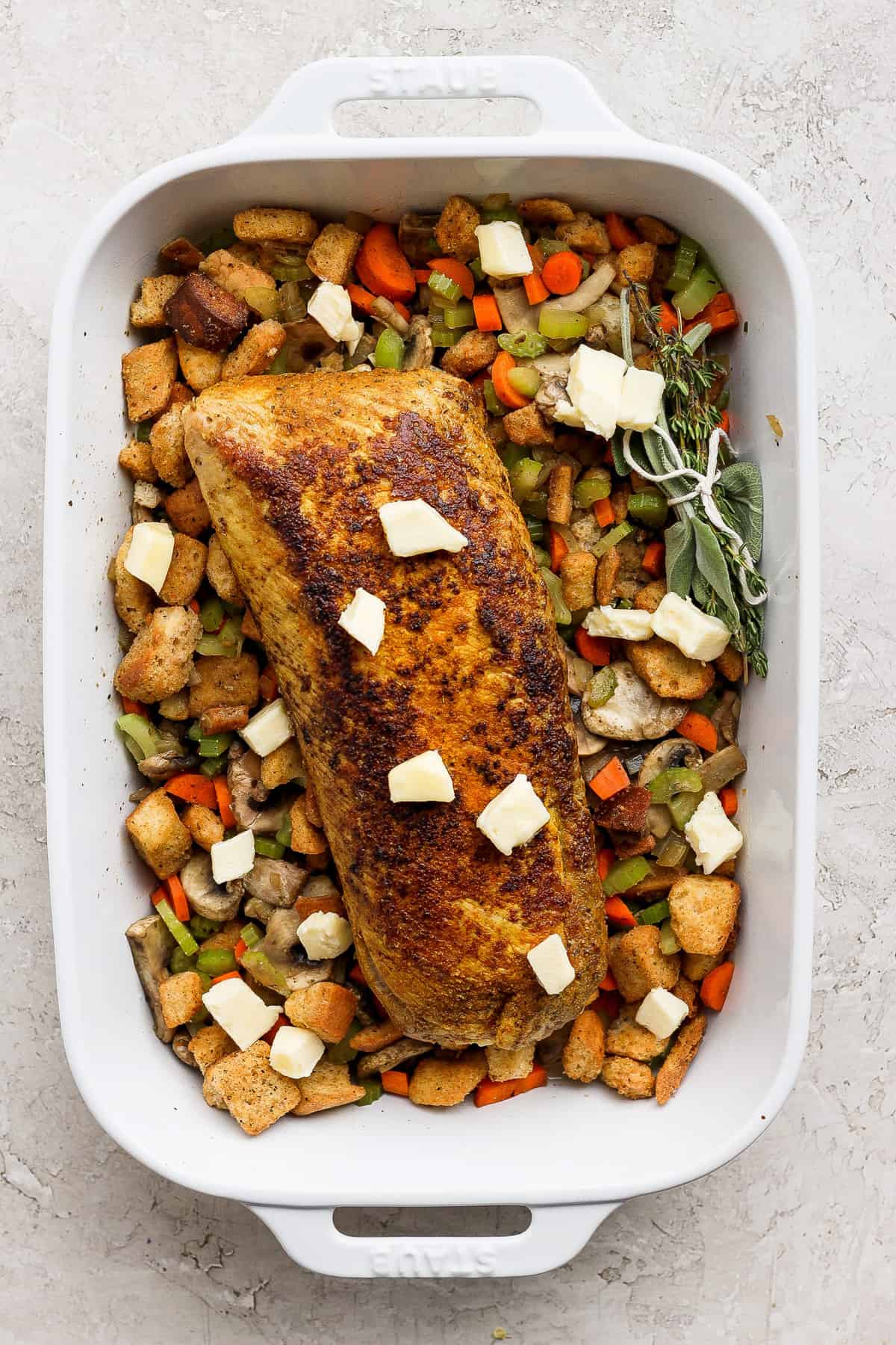 A white baking dish filled with chicken and vegetables.