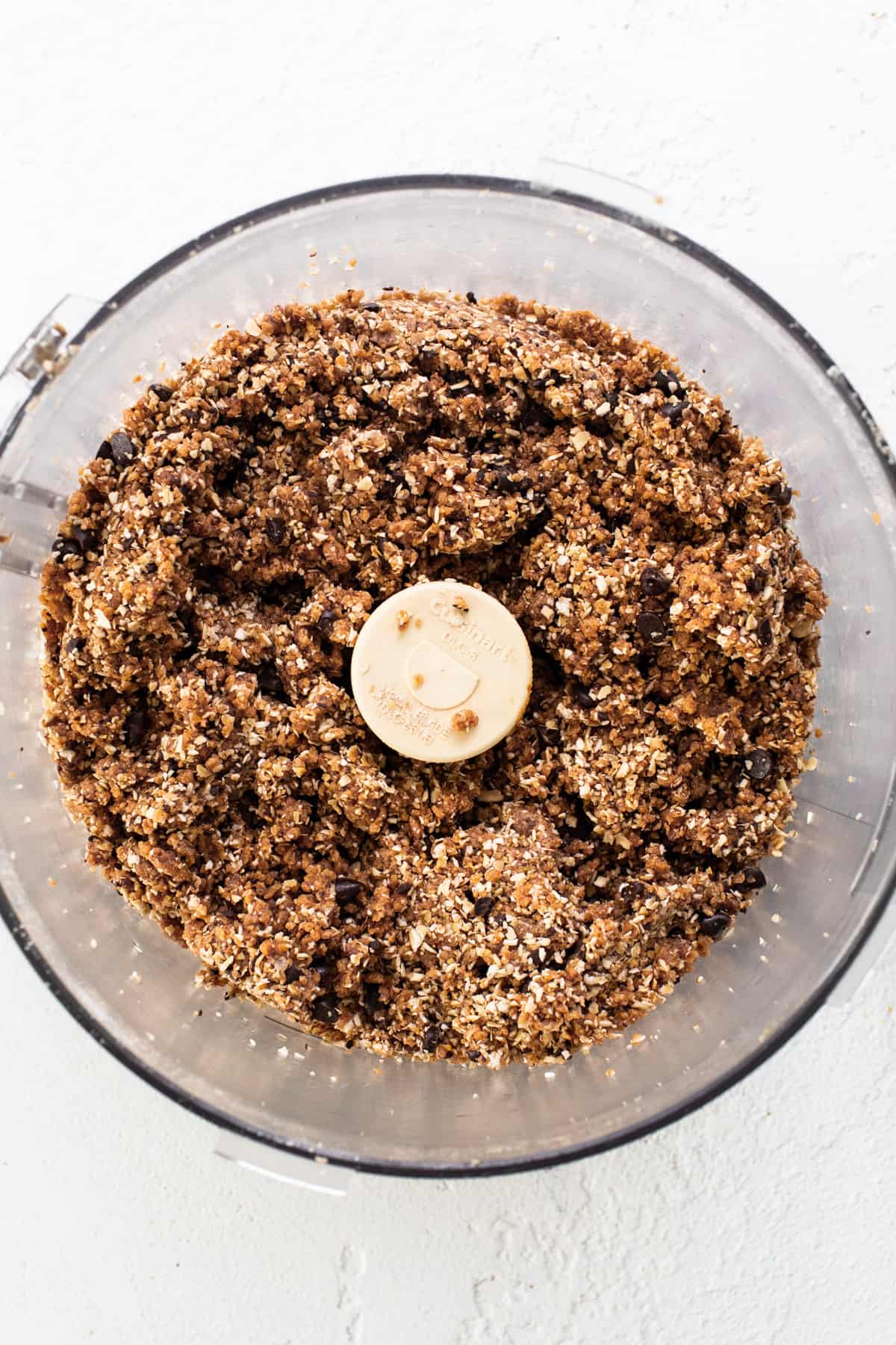 A food processor filled with granola and a banana.