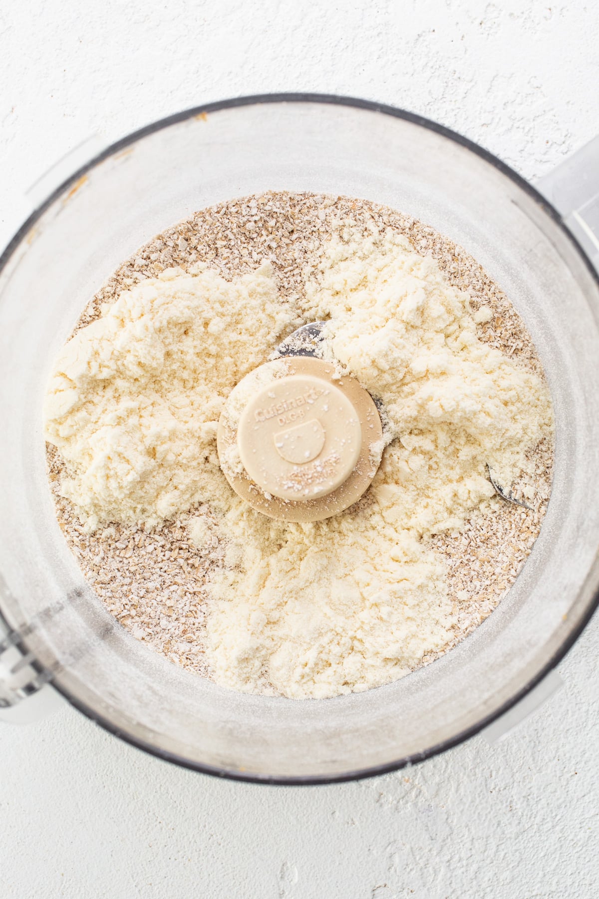 A food processor filled with flour and other ingredients.