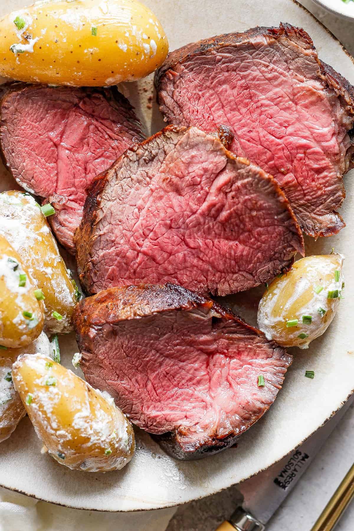 Steak and potatoes on a plate.