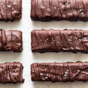 A row of chocolate covered bars on a white surface.