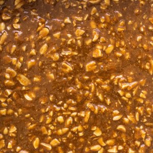 A baking dish filled with caramel and nuts.