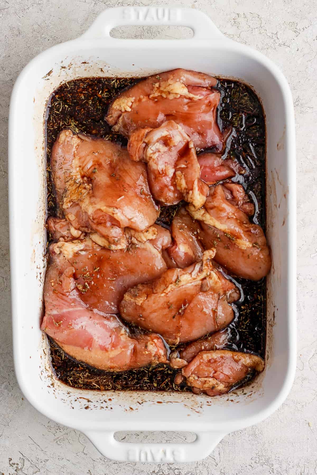 Chicken breasts in a white baking dish.