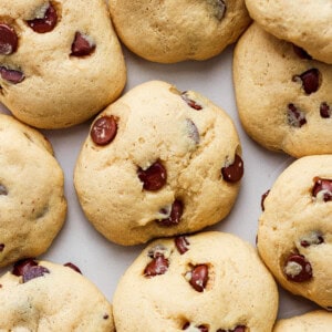 A group of chocolate chip cookies on a white surface.