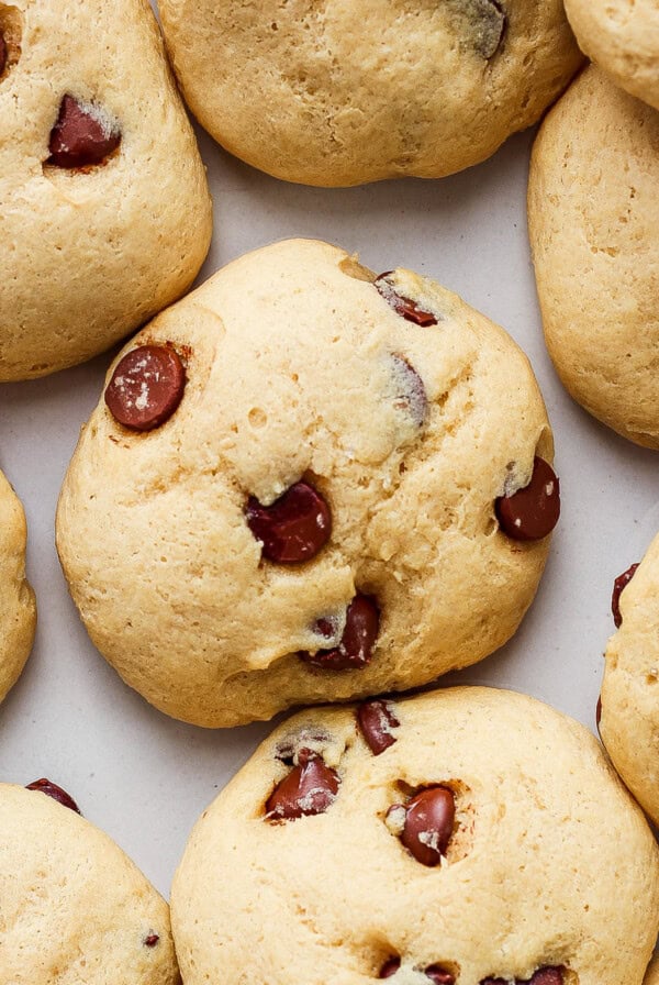 A group of chocolate chip cookies on a white surface.