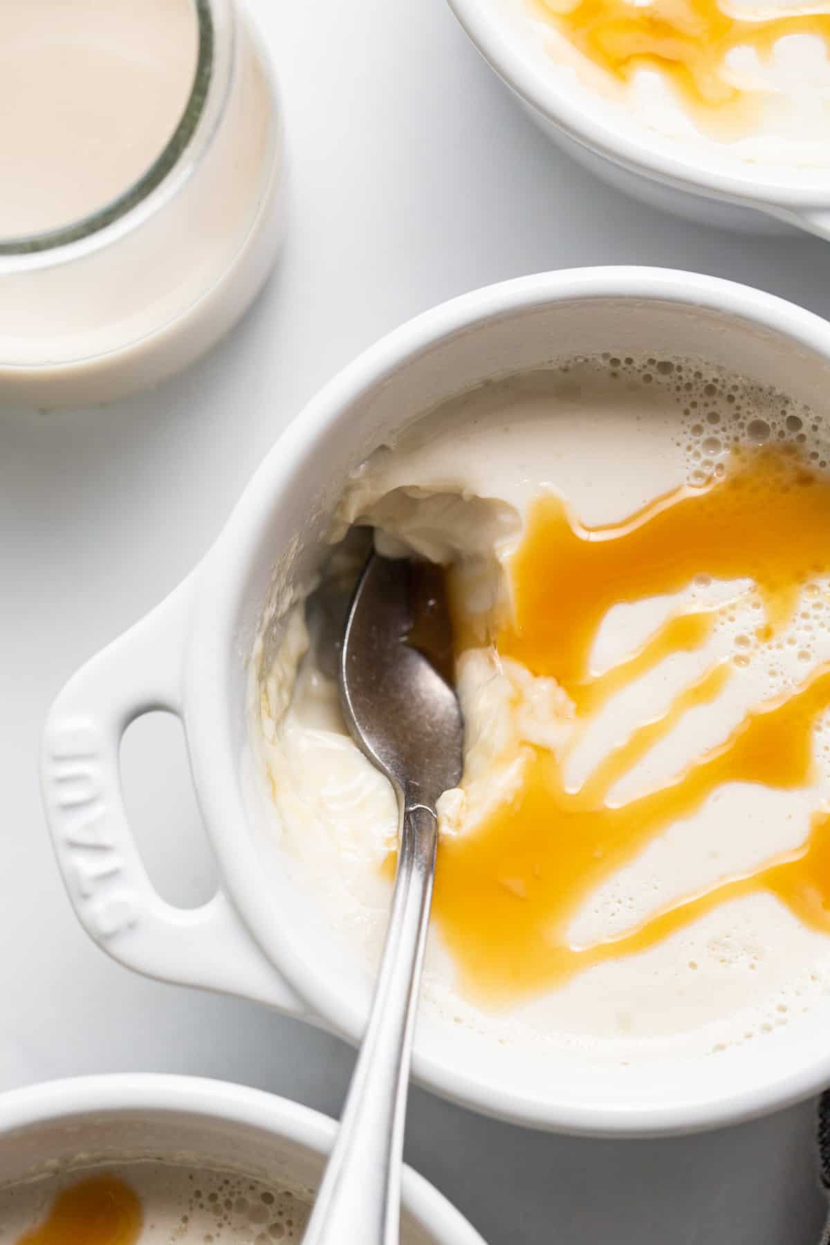 A bowl of ice cream with caramel sauce and a spoon.