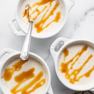 Three white bowls with caramel sauce on them.