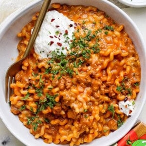 A bowl of pasta with meat and sour cream.