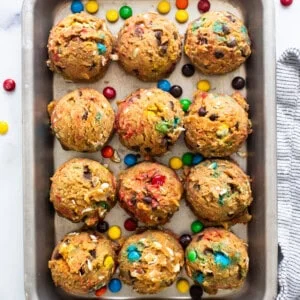 A baking sheet filled with cookies and m&m's.