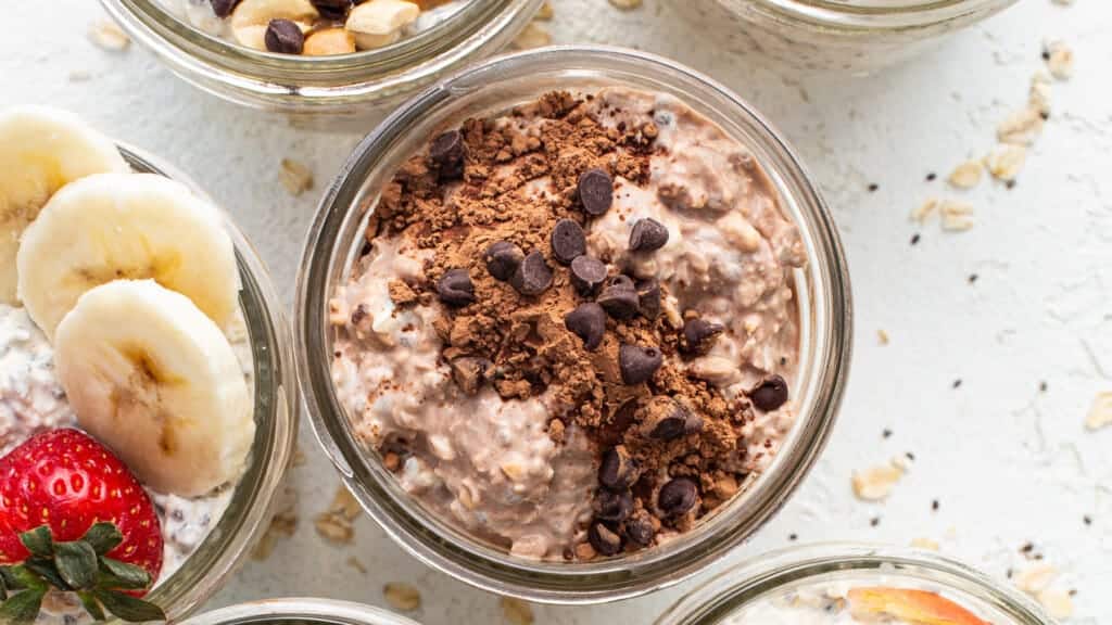 Oatmeal in jars with bananas, strawberries and chocolate chips.