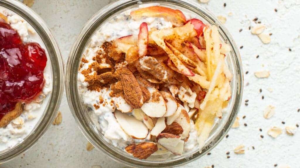 Three bowls of oatmeal with fruit and granola.