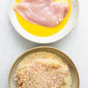 Two bowls with chicken breasts and a bowl of sour cream.