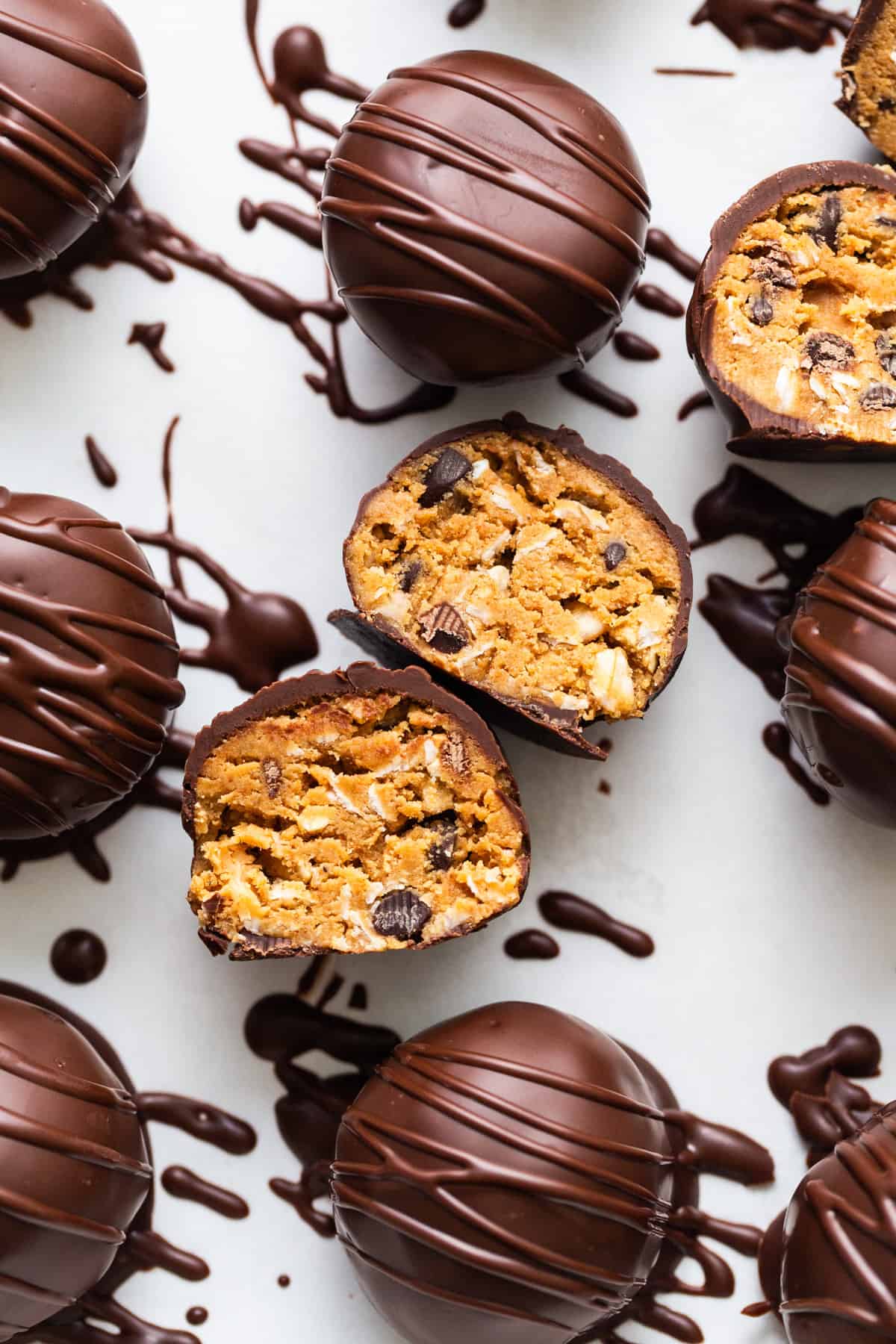 Chocolate covered peanut butter eggs on a white surface.