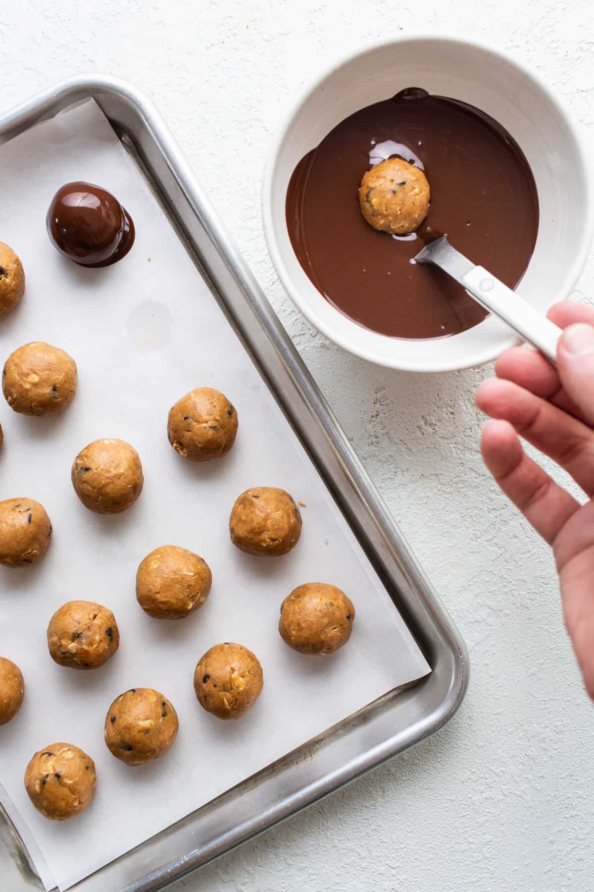 A person is pouring chocolate on a baking sheet.