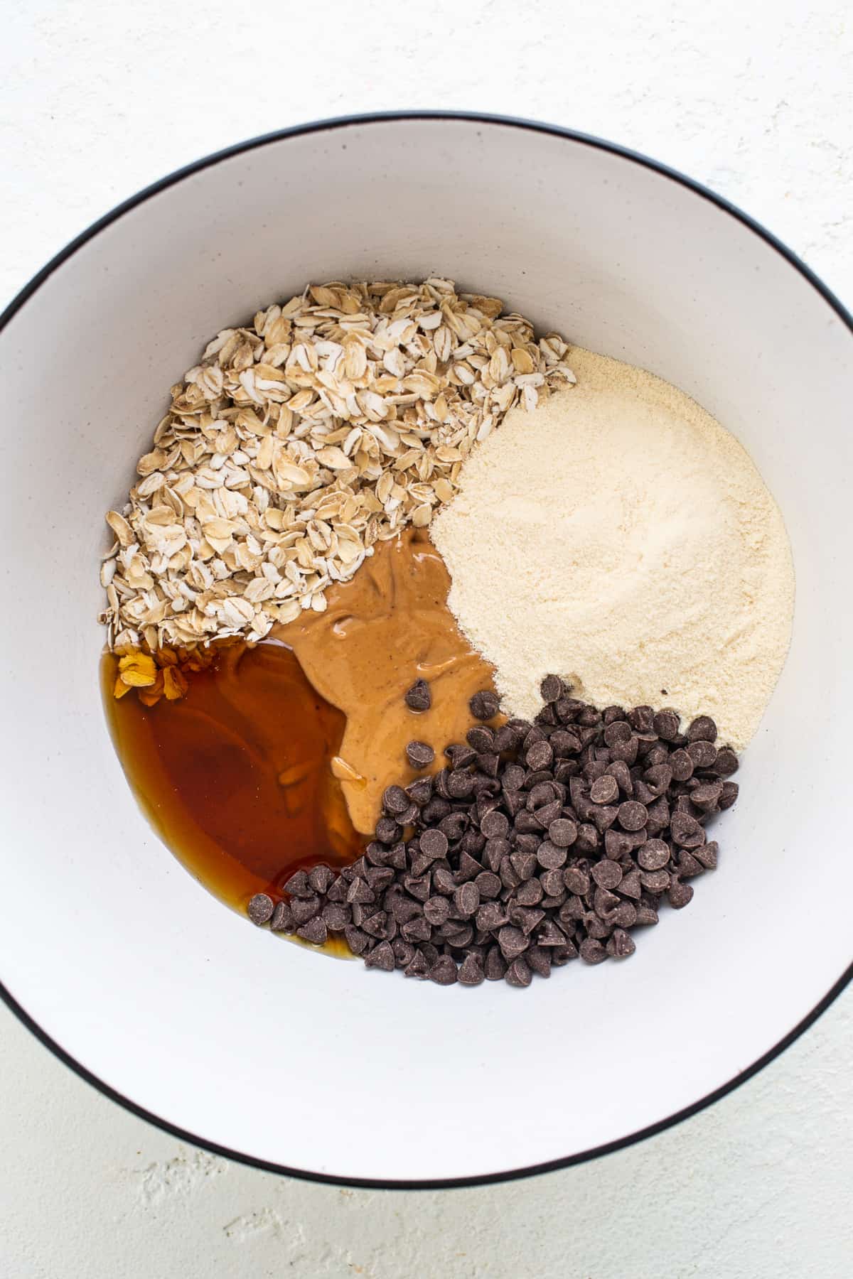 A bowl with ingredients for a chocolate chip cookie.