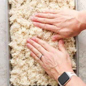 A person putting rice into a pan.