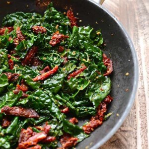 Quinoa and bacon in a skillet on a wooden table.