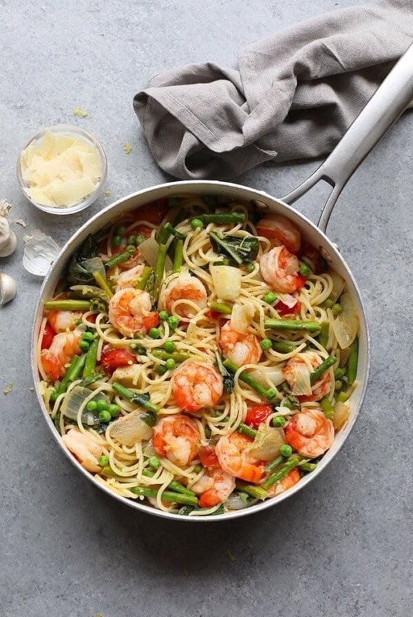 A pan with shrimp scampi and asparagus in it.