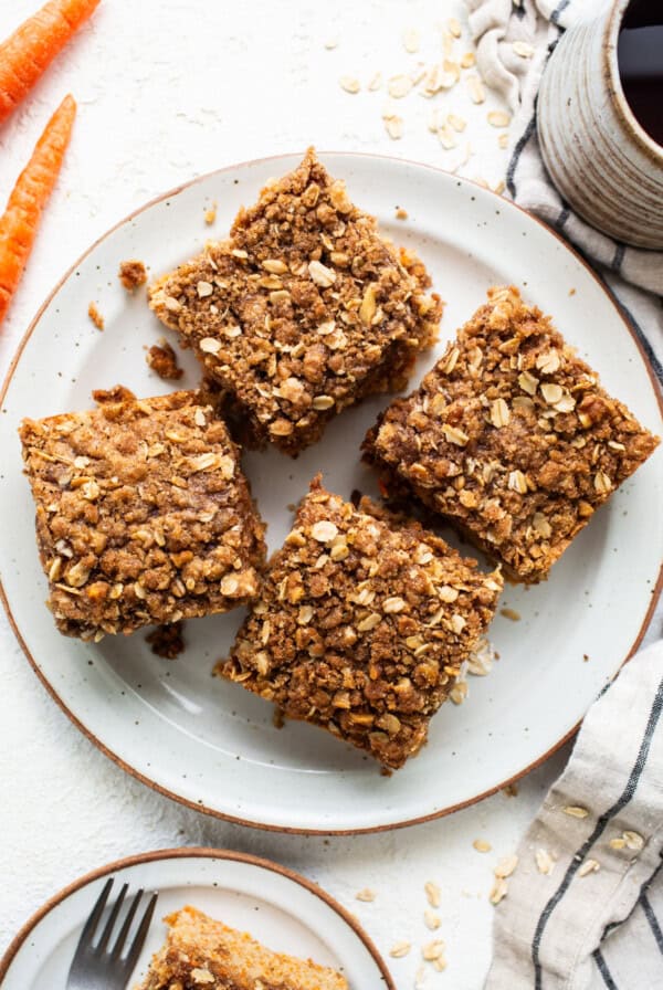 Oat bars on a plate with carrots and a cup of coffee.