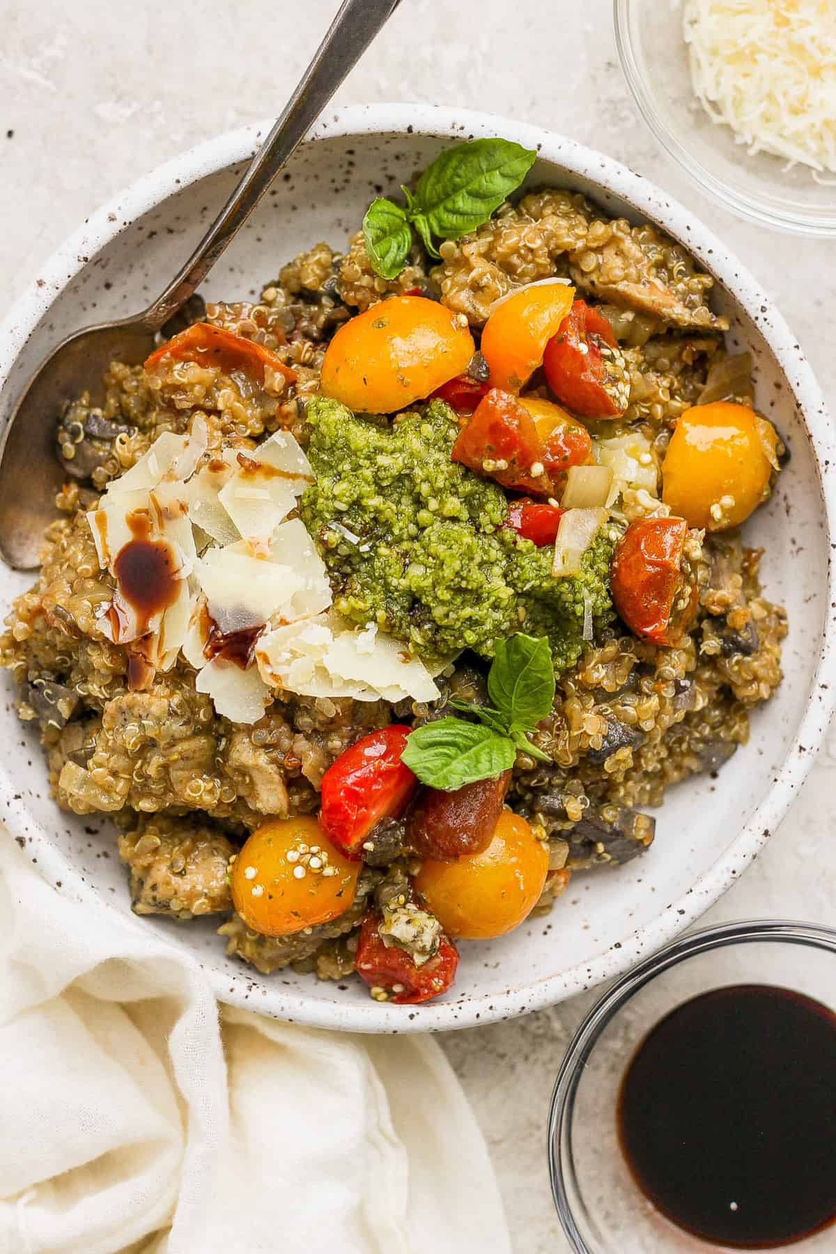 A bowl of pasta with tomatoes and pesto.