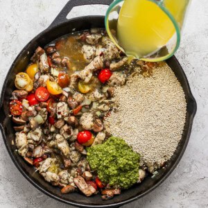 A person pouring olive oil into a skillet.