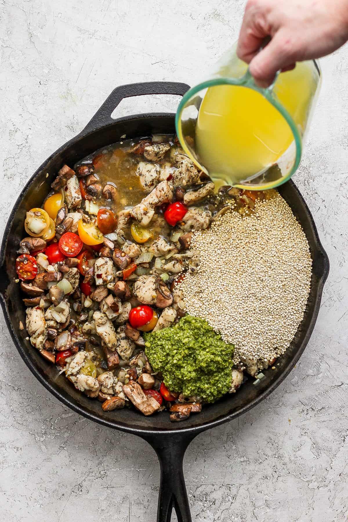 A person pouring olive oil into a skillet.