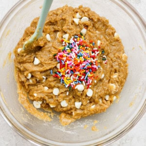 A bowl of brown dough with sprinkles.