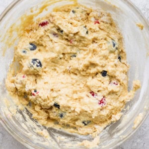 A bowl of dough with blueberries in it.