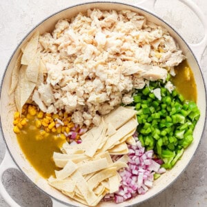 Mexican chicken enchiladas in a pan with corn and peas.