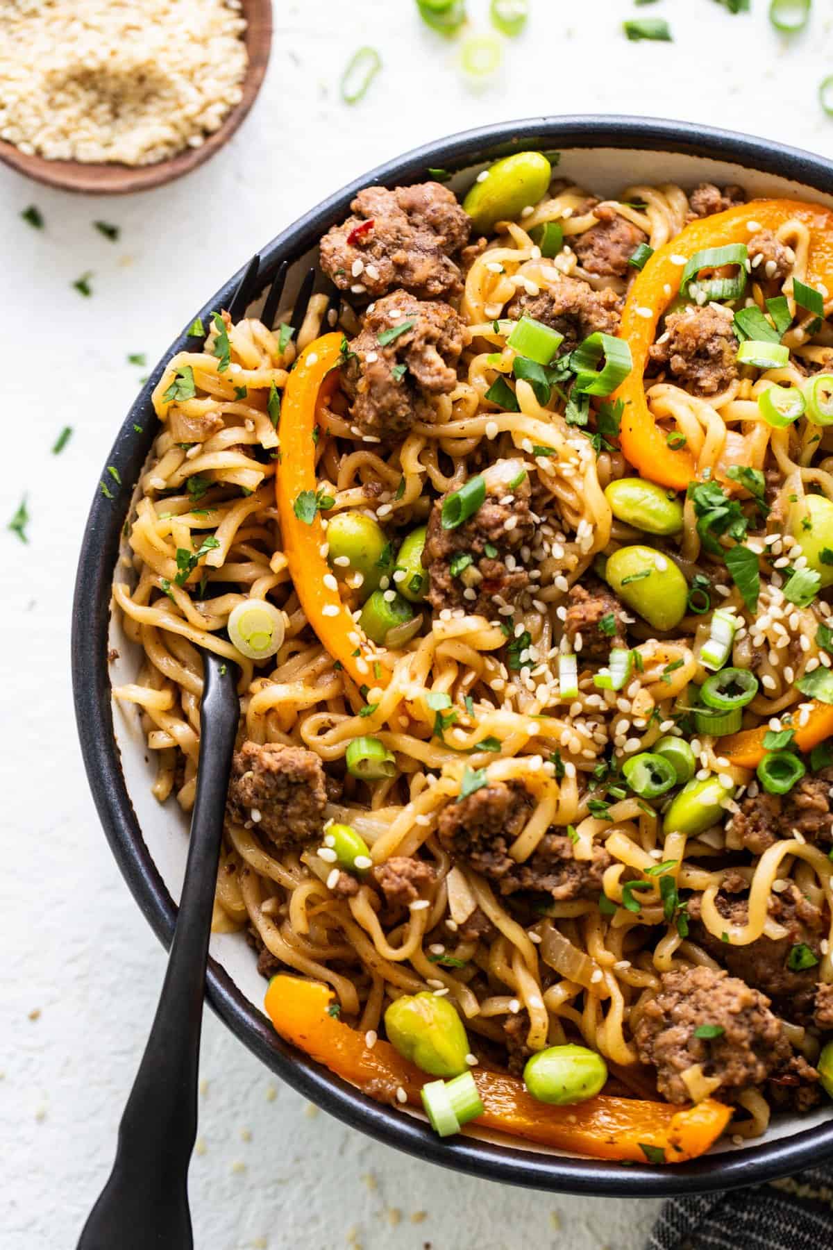 A bowl of noodles with meat and vegetables.