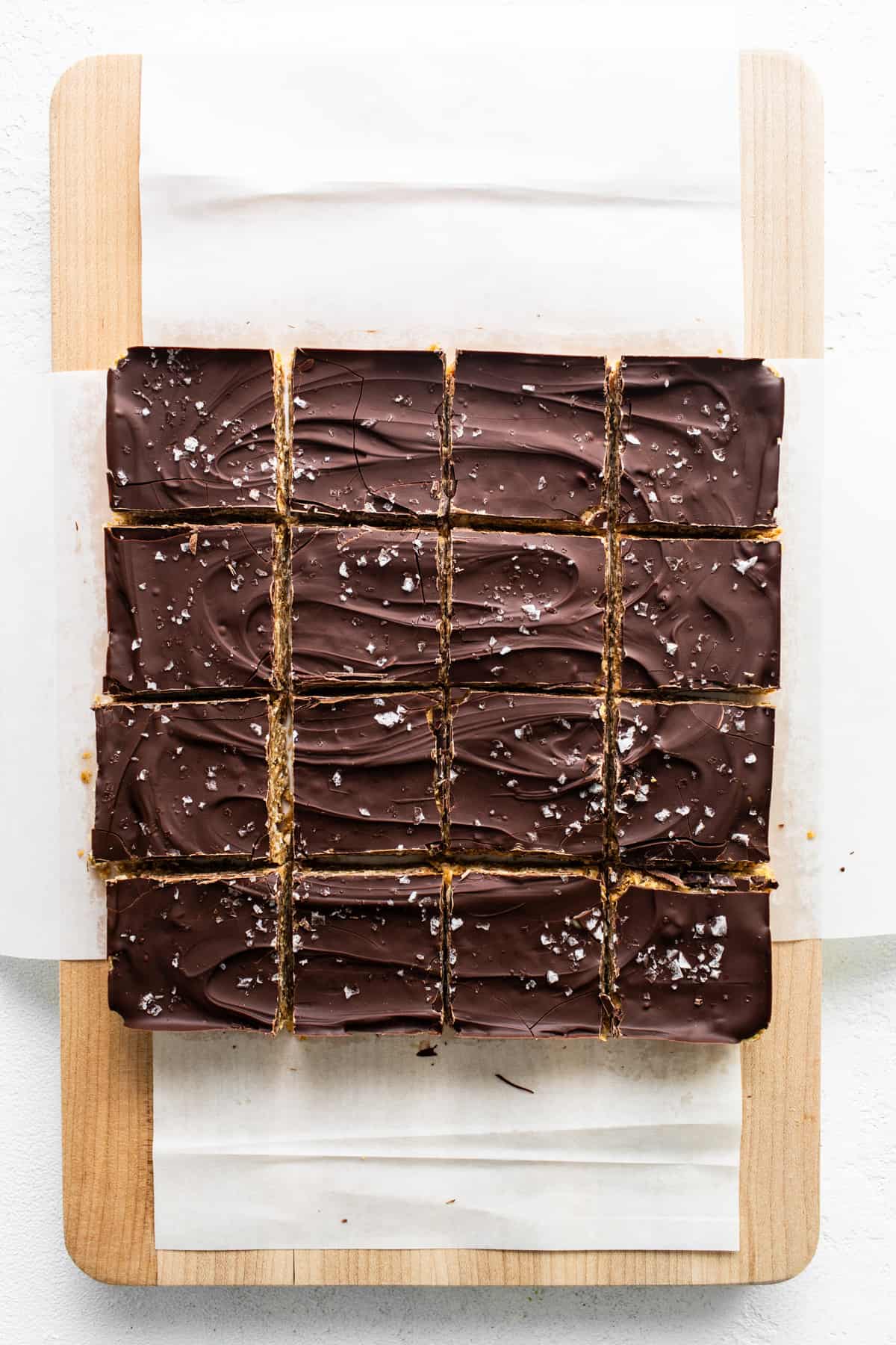 Squares of chocolate bars on a cutting board.