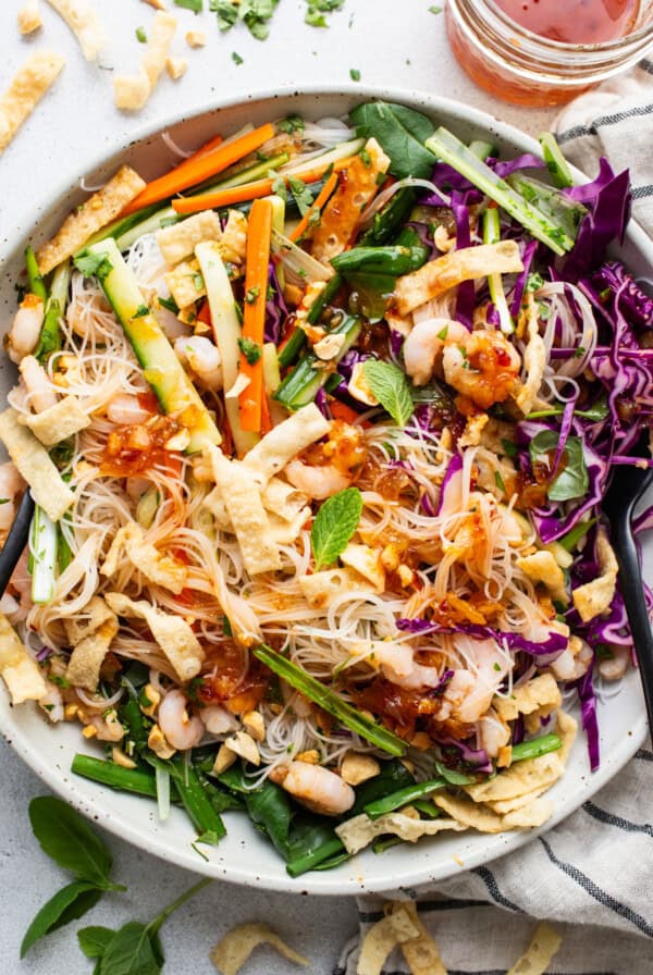 A bowl of asian noodle salad with shrimp and vegetables.