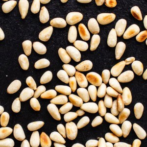 A close up of sesame seeds on a black surface.