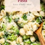 Broccoli pasta in a skillet with a wooden spoon.