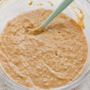 A bowl of thick, mixed batter with a green silicone spatula.