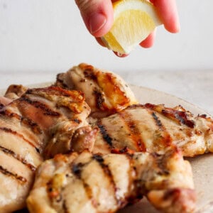 Squeezing lemon juice over grilled chicken breasts.