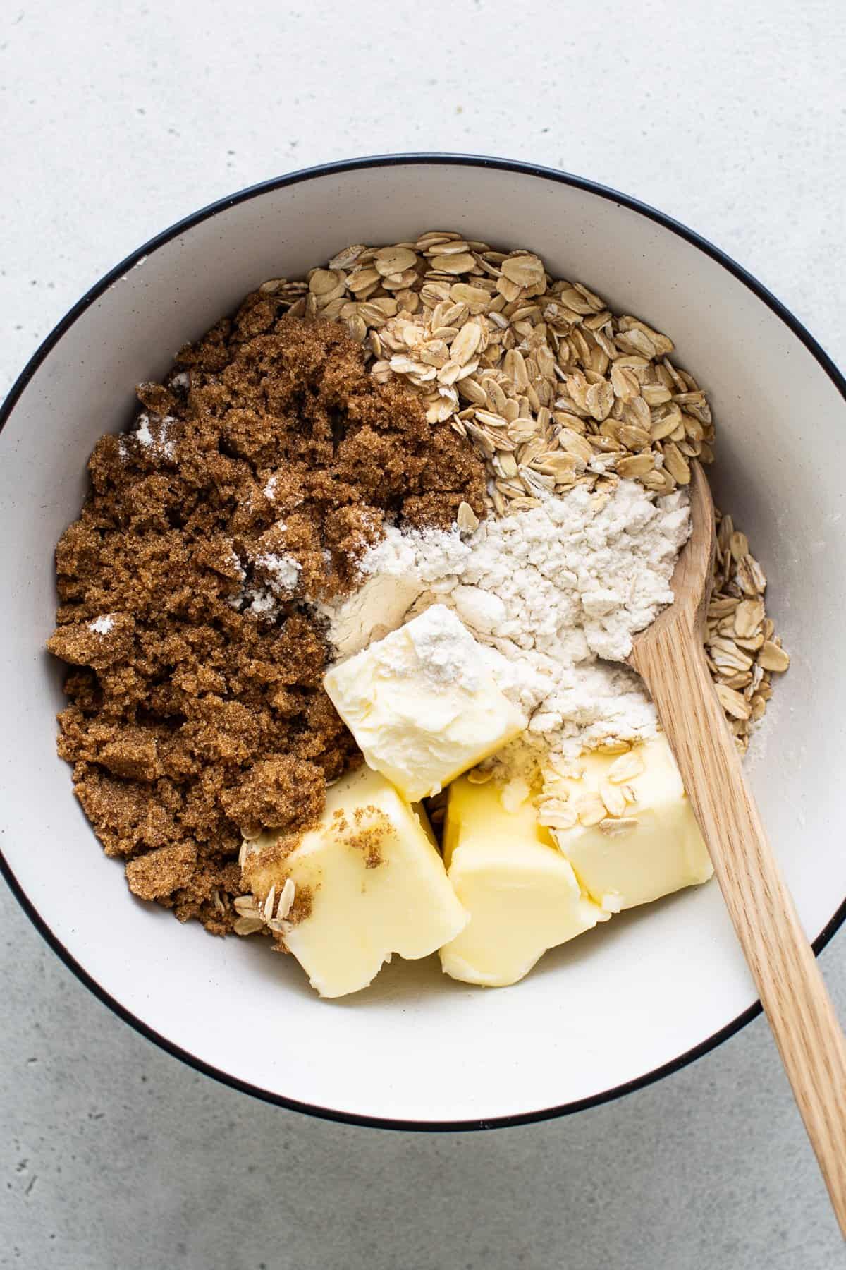 Ingredients for baking in a bowl with a wooden spoon.