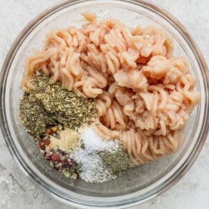 Cooked pasta with a variety of spices in a glass bowl.