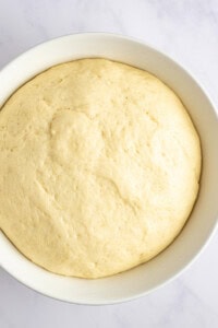 A close-up view of a bowl filled with risen dough.