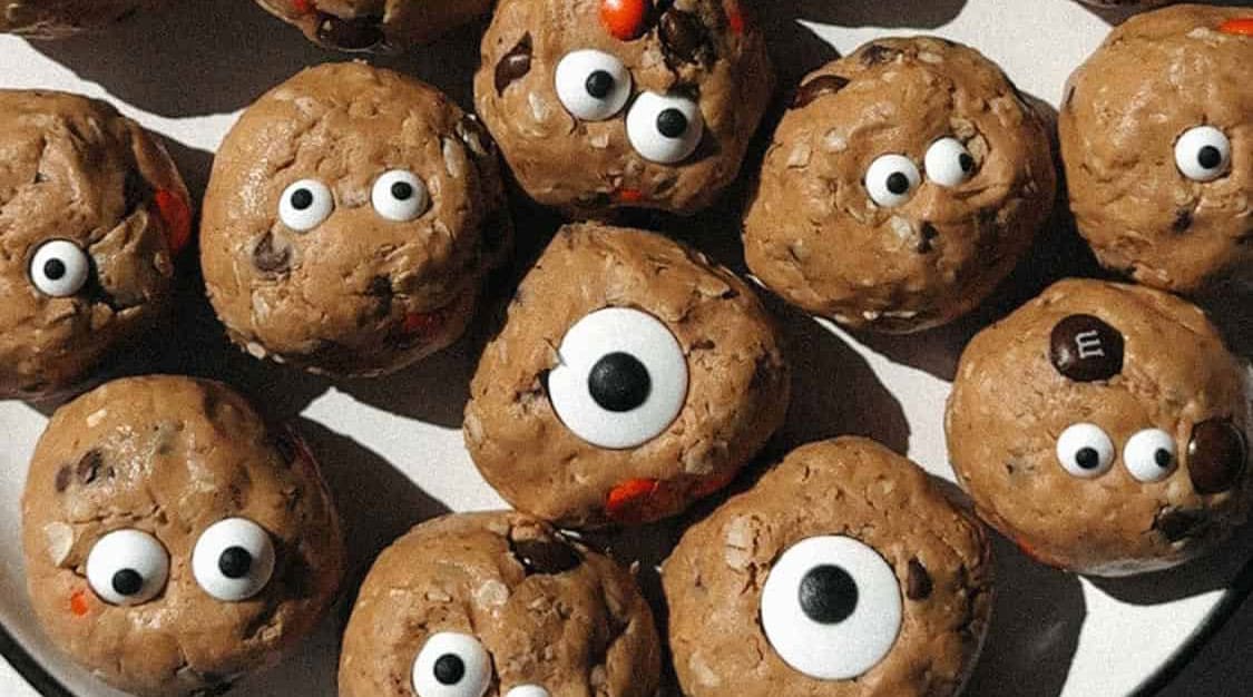 Cookies topped with candy eyes and chocolate chips arranged on a plate.