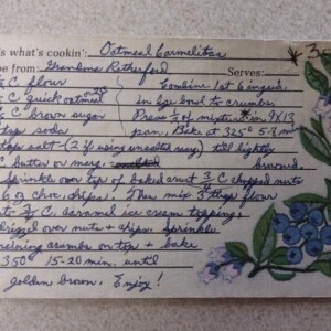 A handwritten recipe card for Carmelita bars with step-by-step instructions and a blue floral illustration on the right.